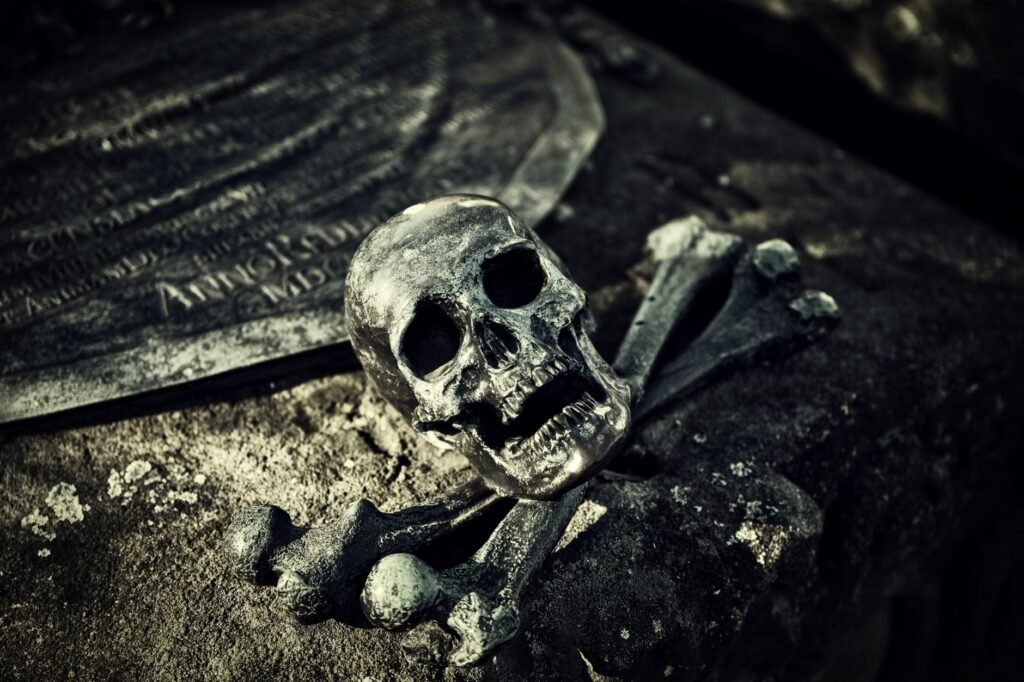 A Haunting Close Up Of A Skull And Crossbones On An Ancient Tombstone In A Spooky Cemetery.