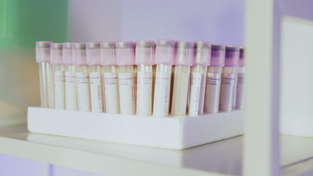A Row Of Laboratory Test Tubes With Pink Caps Neatly Arranged In A Rack.